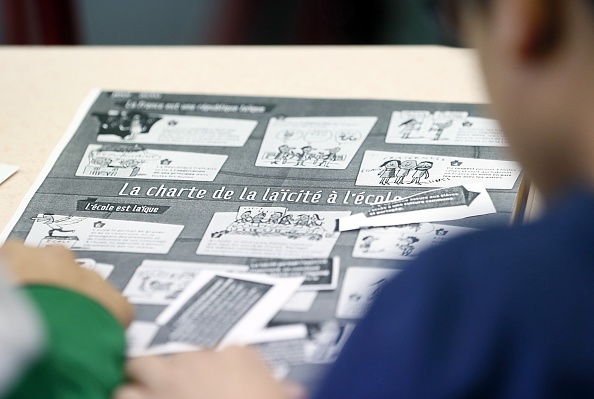 Children look at the chart on secularism in school on December 9, 2014 at the Louis Aragon school in the northern Paris suburb of Pantin on National Secularism Day.                                   AFP PHOTO / PATRICK KOVARIK        (Photo credit should read PATRICK KOVARIK/AFP/Getty Images)