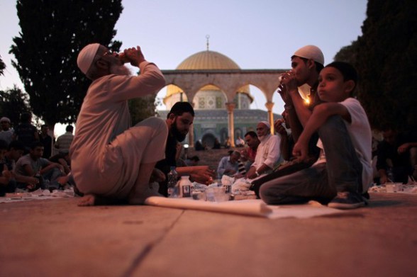 Palestinians eat donated food at the compound of the Dome of the Rock mosque known to Muslims as Noble Sanctuary and to Jews as The Temple Mount in Jerusalem's old city, as they break their fast during the holy month of Ramadan July 25, 2012.  REUTERS/Ammar Awad (JERUSALEM - Tags: RELIGION)