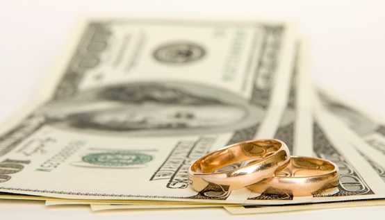 Wedding rings and money on a white background