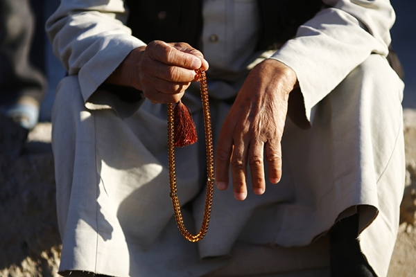 A Kurdish refugee man from the Syrian town of Kobani holds prayer beads in a camp in the southeastern town of Suruc, Sanliurfa province October 24, 2014. REUTERS/Kai Pfaffenbach (TURKEY - Tags: MILITARY CONFLICT POLITICS RELIGION) - RTR4BEW0