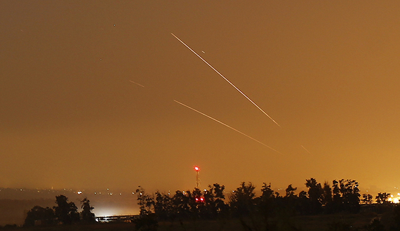 Light streaks and trails are seen as rockets are launched from Gaza towards Israel before a 72-hour cease fire was due to expire