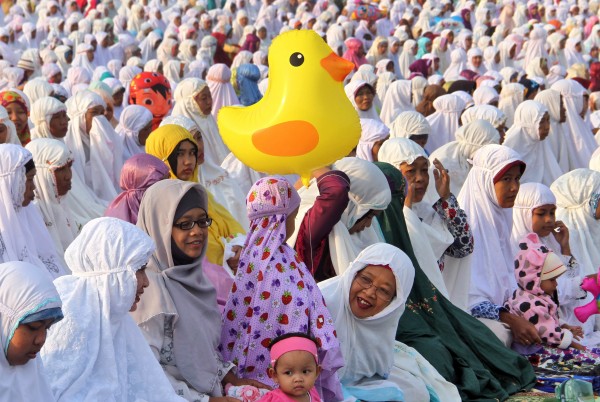 Muslim women attend an Eid al-Fitr prayer marking the end of the holy fasting month of Ramadan at Parangkusumo beach in Yogyakarta, Indonesia, Friday, July 17, 2015. (AP Photo/Slamet Riyadi)
