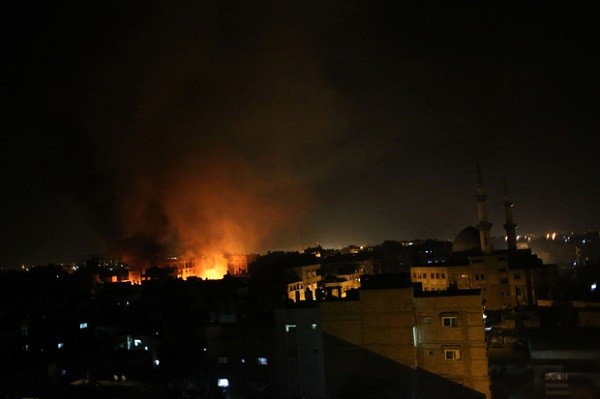 A picture taken late at night on August 23, 2014 shows smoke and fire billowing from a shopping center following an Israeli air strike in the southern Gaza Strip town of Rafah. An Israeli air strike killed at least two Palestinians in Gaza as militants kept up rocket fire, a day after an Egyptian call for an open-ended ceasefire to enable new truce talks. AFP PHOTO / SAID KHATIB