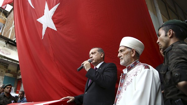 Turkish President Tayyip Erdogan (3rd R) speaks next to the flag-draped coffin of slain police officer Ahmet Camur, who was killed during clashes with PKK militants, during a funeral ceremony in Trabzon, Turkey, August 16, 2015. As efforts to form a new government flounder and Turkish jets bombard Kurdish militants, Erdogan is hoping to turn Turkey's deepest uncertainty in more than a decade to his advantage. Picture taken August 16, 2015. REUTERS/Yasin Bulbul/Presidential Palace Press Office/Handout via Reuters ATTENTION EDITORS - THIS PICTURE WAS PROVIDED BY A THIRD PARTY. REUTERS IS UNABLE TO INDEPENDENTLY VERIFY THE AUTHENTICITY, CONTENT, LOCATION OR DATE OF THIS IMAGE. FOR EDITORIAL USE ONLY. NOT FOR SALE FOR MARKETING OR ADVERTISING CAMPAIGNS. NO SALES. NO ARCHIVES. THIS PICTURE IS DISTRIBUTED EXACTLY AS RECEIVED BY REUTERS, AS A SERVICE TO CLIENTS.