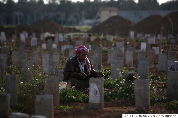 A Syrian man prays over the grave of his son, who was killed during shelling, at a cemetery in the rebel-held Damascus suburb of Douma, on March 5, 2015. Syria's conflict began as a popular uprising but evolved into a multi-front civil war that has divided the country into a patchwork of fiefdoms controlled by different factions, including the extremist Islamic State group. AFP PHOTO / ABD DOUMANY        (Photo credit should read ABD DOUMANY/AFP/Getty Images)