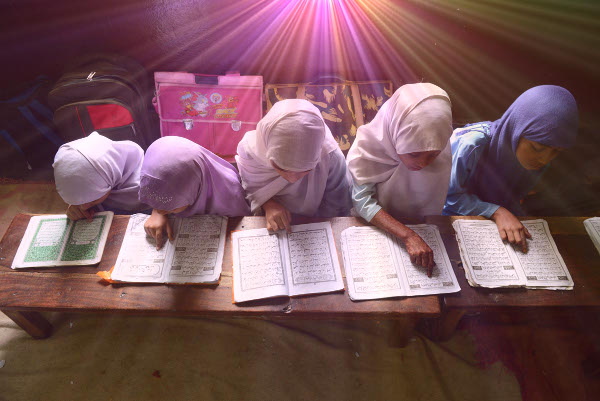 TOPSHOTS Indian Muslim girls recite the Holy Quran in their class room during the holy month of Ramadan at Madrasatur-Rashaad religious school in Hyderabad on July 17, 2013.  As well as abstinence and fasting during Ramadan, Muslims are encouraged to pray and read the Quran during Islam's holiest month.  AFP PHOTO / Noah SEELAMNOAH SEELAM/AFP/Getty Images ORG XMIT: