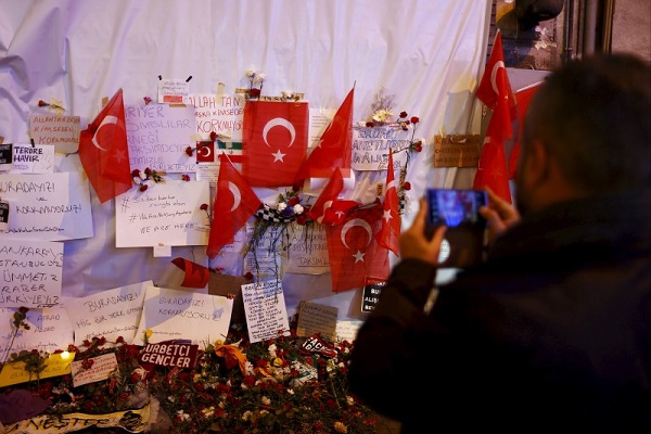 A man takes photos of tributes left at the scene of a suicide bombing at Istiklal street, a major shopping and tourist district, in central Istanbul, Turkey March 20, 2016. REUTERS/Osman Orsal