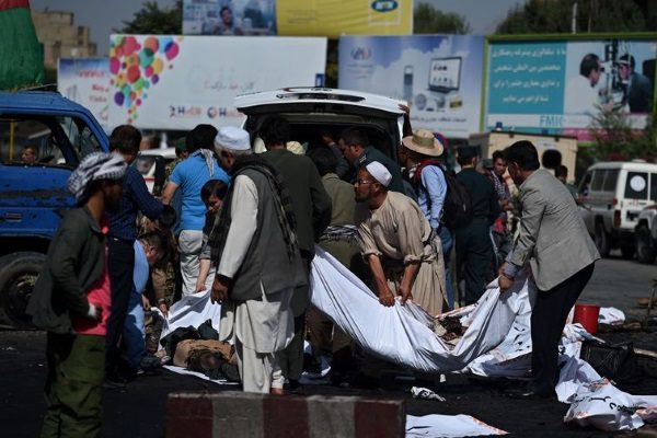 Afghan volunteers carry the bodies of victims at the scene of a suicide attack that targeted crowds of minority Shiite Hazaras during a demonstration at the Deh Mazang Circle of Kabul on July 23,2016.  A powerful explosion on July 23, ripped through crowds of minority Shiite Hazaras in Kabul who had gathered to protest over a power line, killing at least 20 people and leaving 160 others wounded, officials said. No group has so far claimed responsibility for the blast, but it comes in the middle of the Taliban's annual summer offensive, which the insurgents are ramping up after a brief lull during the recent holy fasting month of Ramadan. The scene of the blast was littered with charred bodies and dismembered limbs, with ambulances struggling to reach the scene as authorities had overnight blocked key intersections with stacked shipping containers to impede movement of the protesters. / AFP / WAKIL KOHSAR