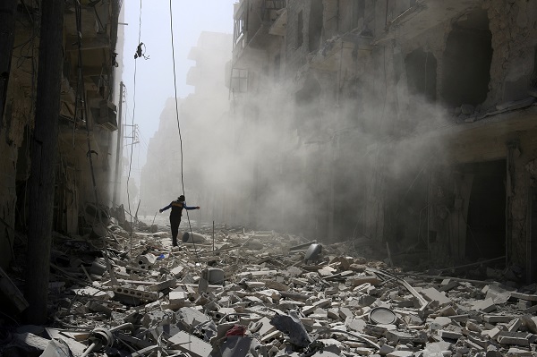 A man walks on the rubble of damaged buildings after an airstrike on the rebel held al-Qaterji neighbourhood of Aleppo, Syria. REUTERS/Abdalrhman Ismail