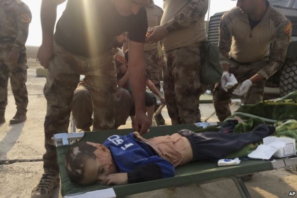 Soldiers give the first aid to a boy injured during the clashes between Iraq's elite counterterrorism forces and Islamic State militiants in the village of Tob Zawa, about 9 kilometers (5½ miles) from Mosul, Iraq, Oct. 25, 2016. Source: VOA News