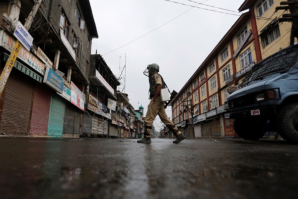An Indian policeman wearing riot gear patrols on a deserted road during a curfew in Srinagar, July 10, 2016. REUTERS/Danish Ismail