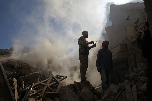 Smoke rises while men inspect damaged buildings after an airstrike on the rebel-held town of Darat Izza, province of Aleppo, Syria November 5, 2016. REUTERS/Ammar Abdullah