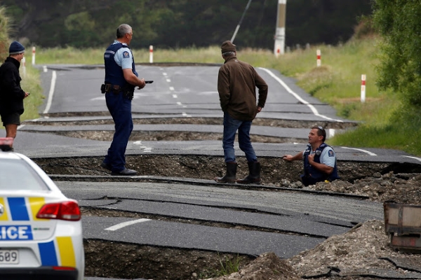 Policemen and locals look at damage following an earthquake, along State Highway One near the town of Ward, south of Blenheim on New Zealand's South Island, November 14, 2016. REUTERS/Anthony Phelps